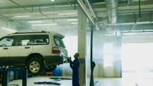 Technicien manipulant un tuyau de climatisation sur un moteur